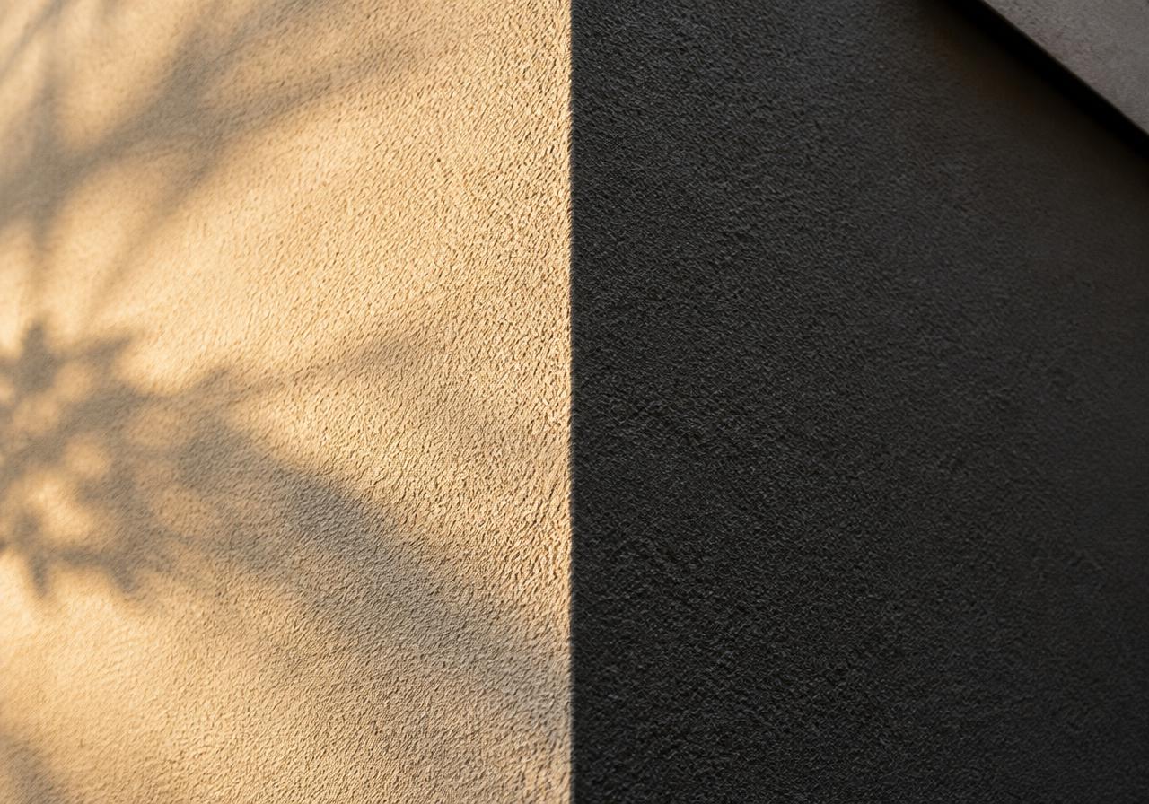 Close-up of coarse acrylic render texture in ivory and charcoal